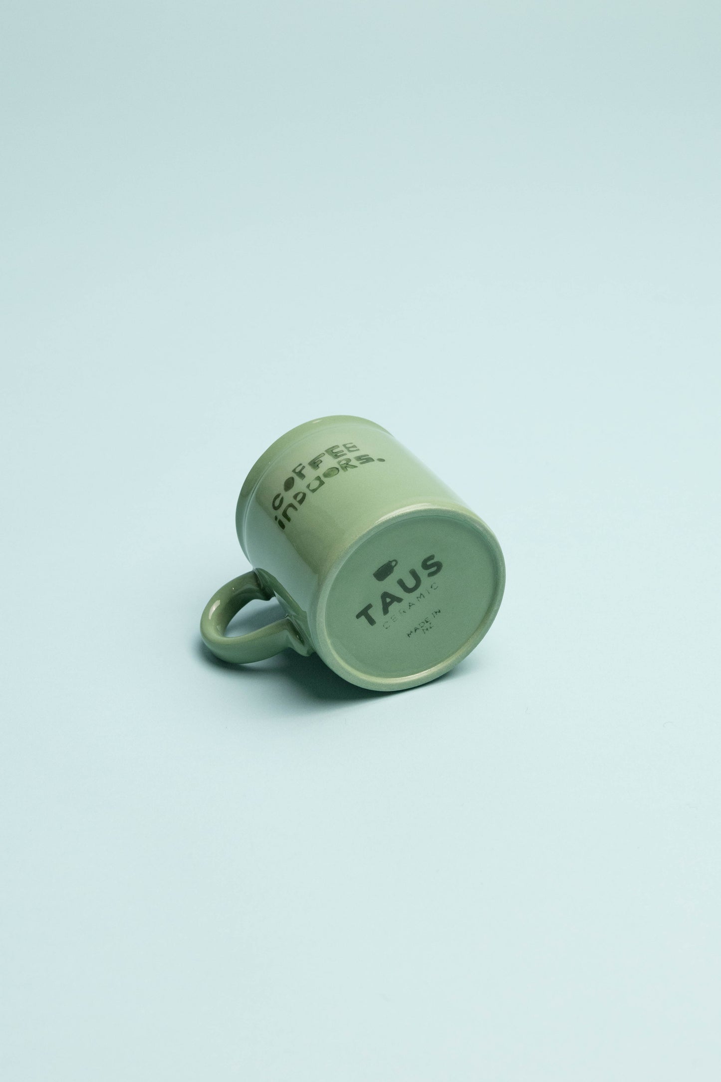 Coffee Outdoors x Taus Diner Cup - Green displayed against a pastel backdrop, showcasing its classic diner style and handcrafted design.
