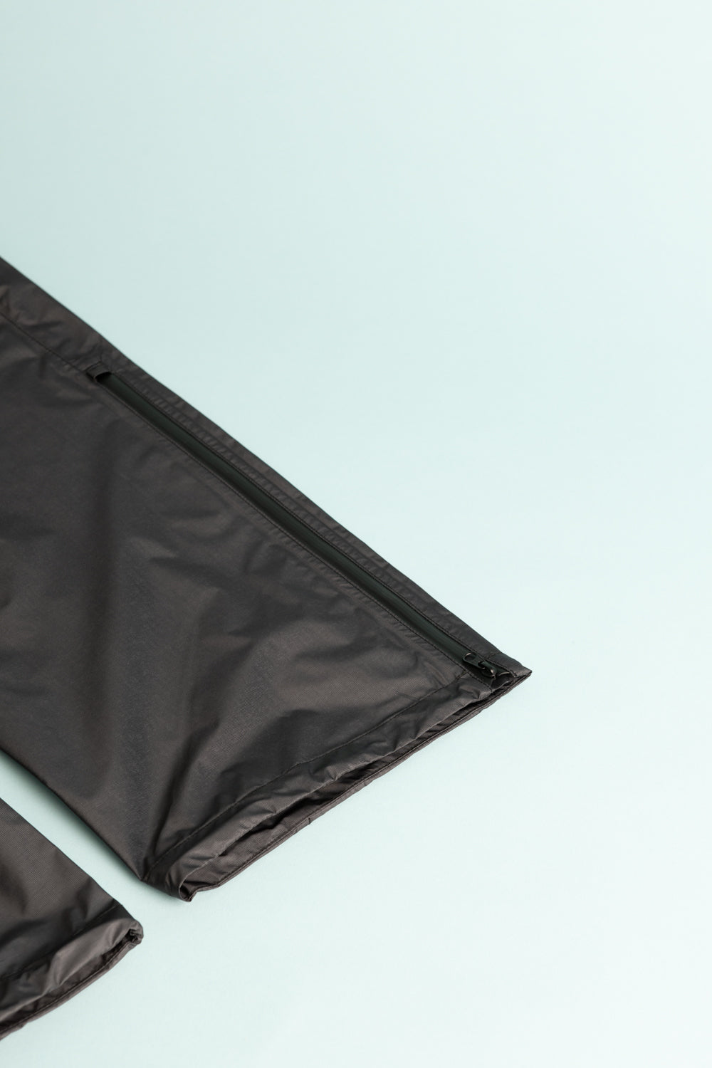 Montbell US Men's Dry-Tec U.L. Rain Pants in black, showcasing the zippered pocket detail.