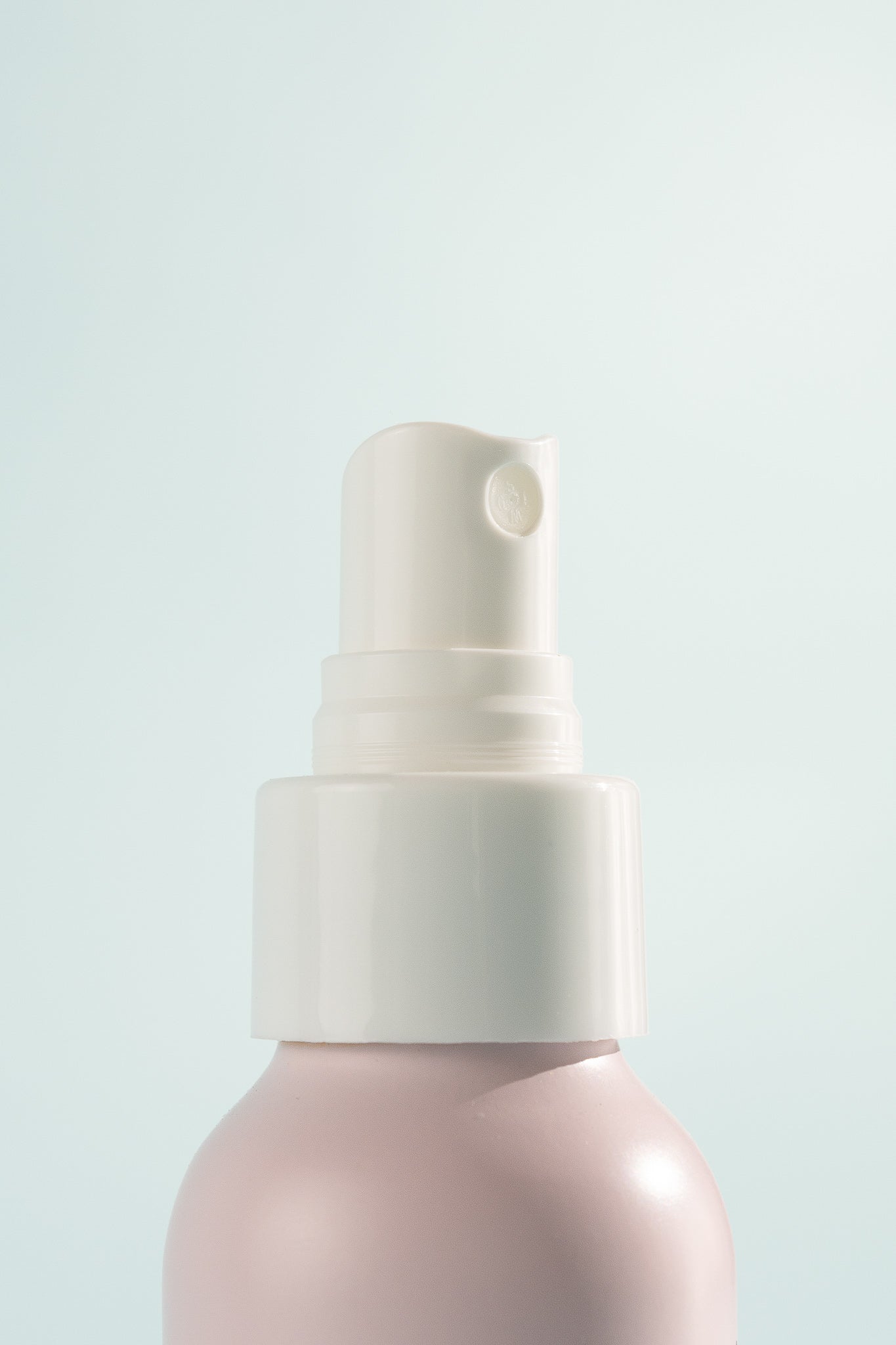 Atlas Rose Spray Deodorant bottle with a fine mist nozzle against a light blue background.