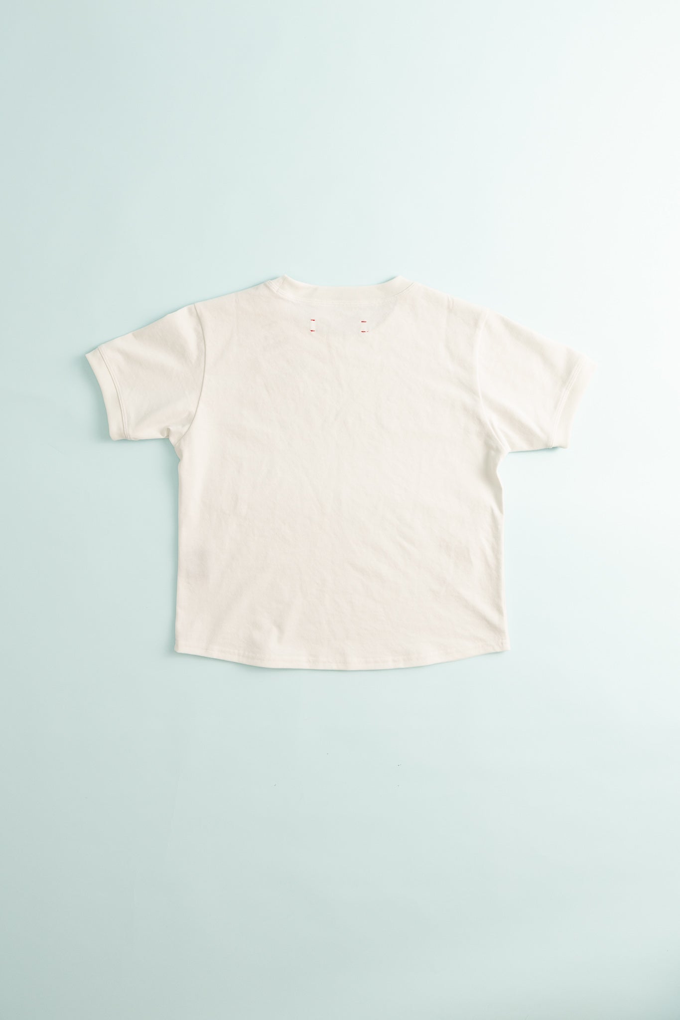 Back view of District Vision Women's Fitted Cropped T-Shirt - Off White, showcasing its smooth fabric and cropped hem design.