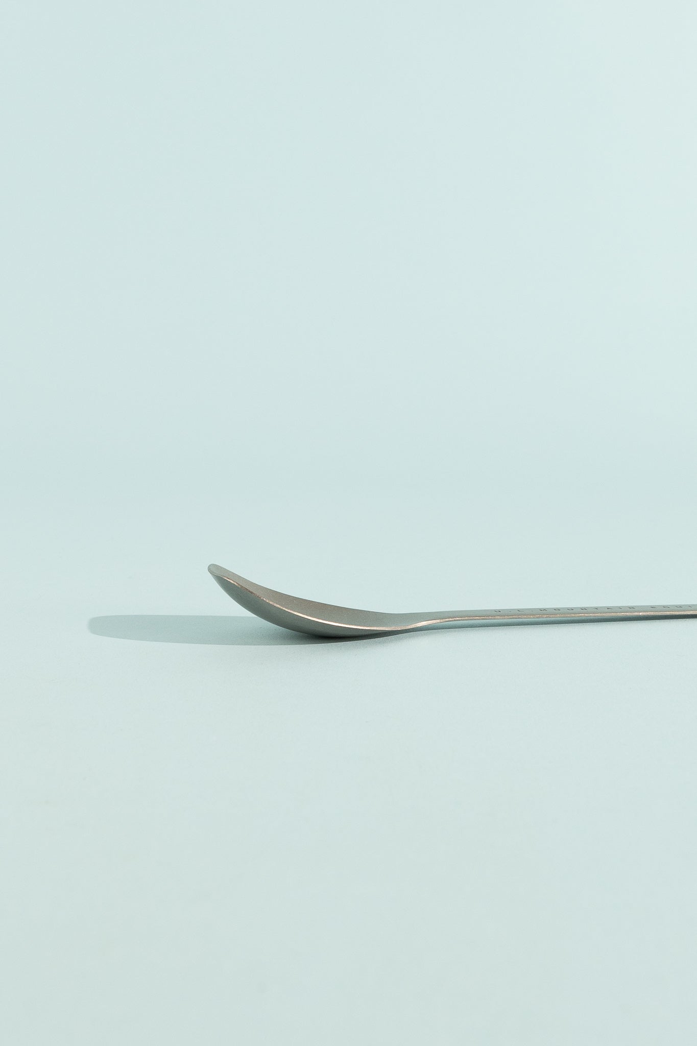 Evernew SputuraTi spoon lying flat on a pale background, showcasing its sleek design.