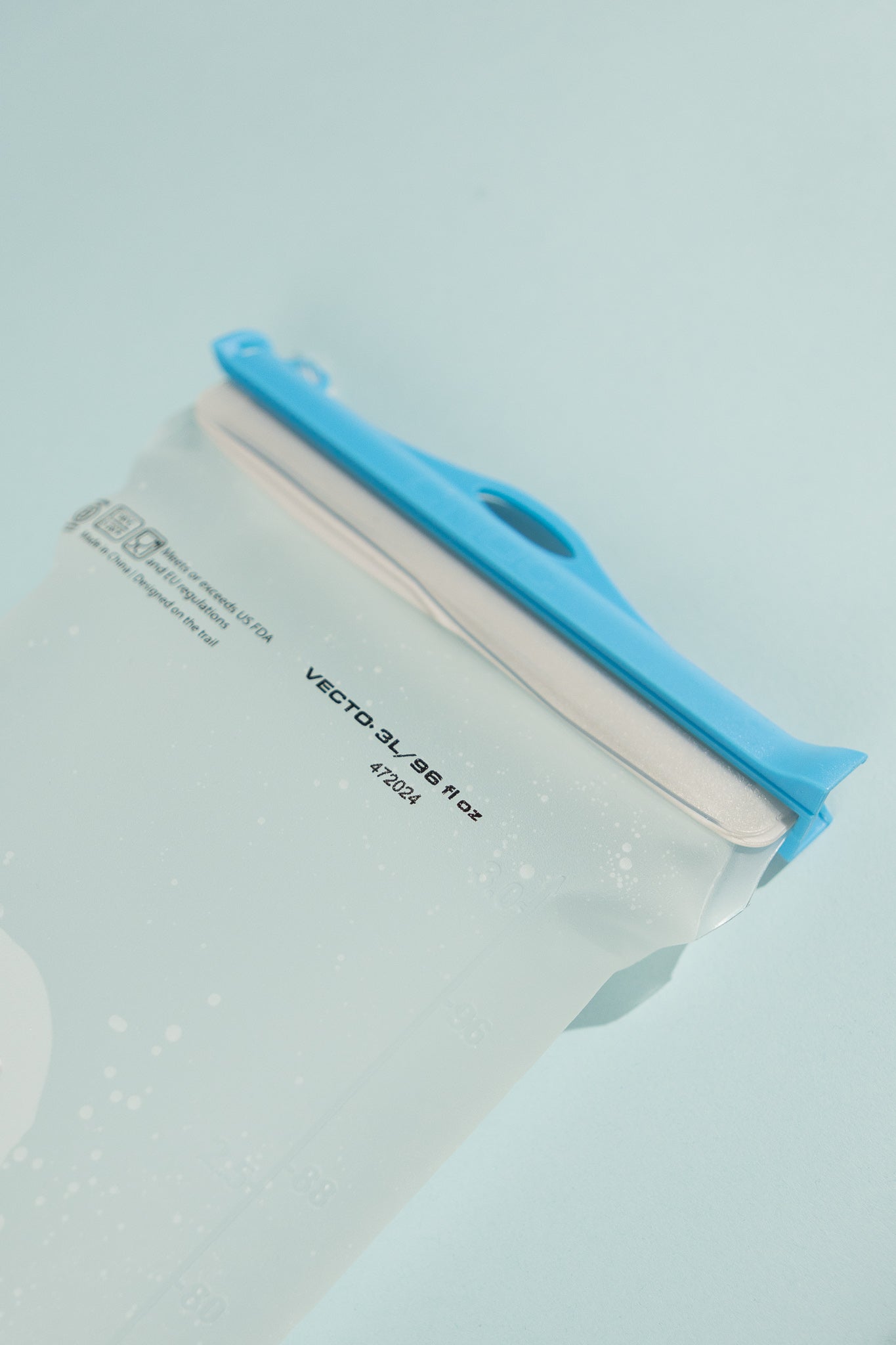 Close-up of Vecto 3L water bladder with a blue cap on a light blue background.