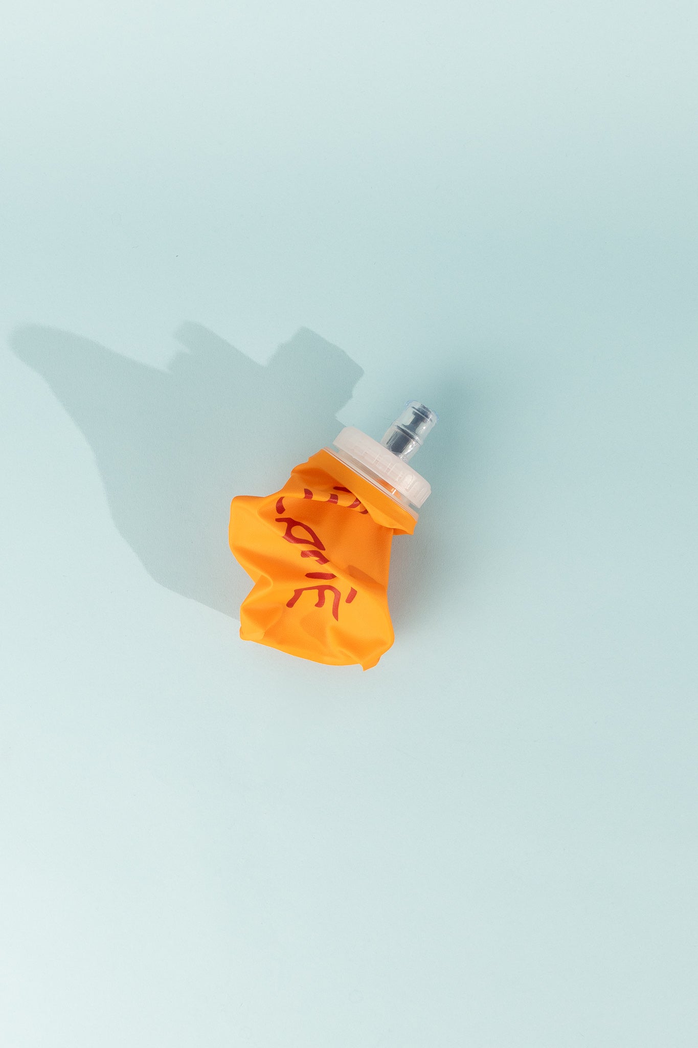 Floppy Water Bottle shown in orange color, flexible and collapsible for easy transport and use.