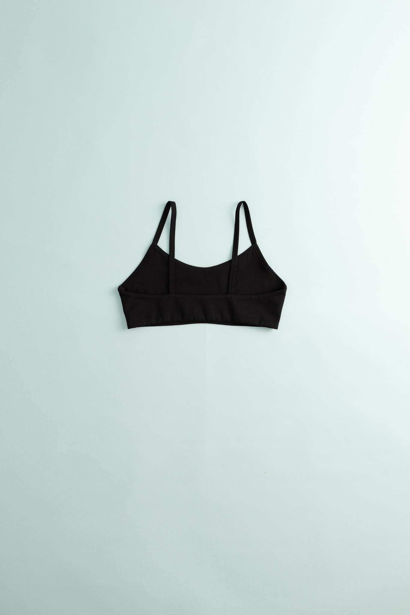 District Vision Women's Light Support Interlock Bra in black color on a light background.