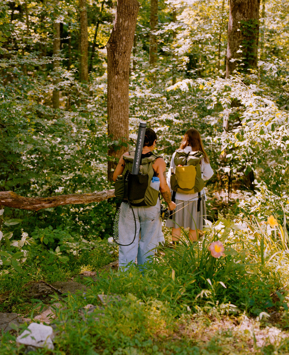 Minimalism for hikers who like good shit: two hikers exploring a lush forest with backpacks.