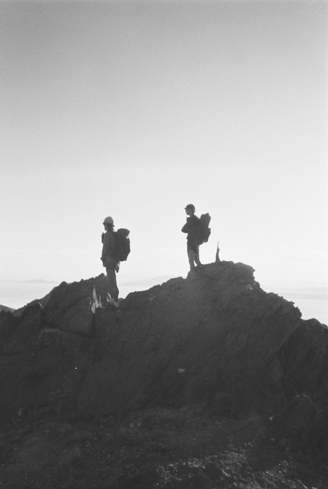 Two hikers standing on a rocky summit, showcasing the adventure spirit of Pa'lante Packs.