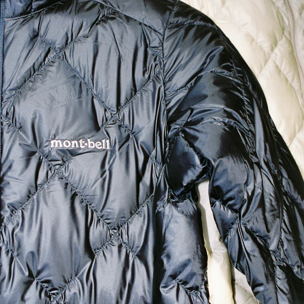 A close-up of a Montbell jacket showcasing its lightweight, puffy design and distinctive stitching.