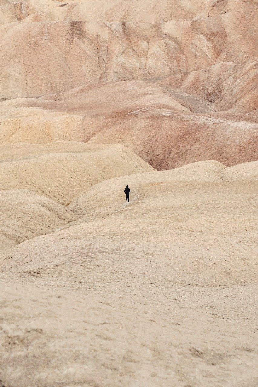 A solitary figure walking through the textured landscape, representing tools for mindful athletes.