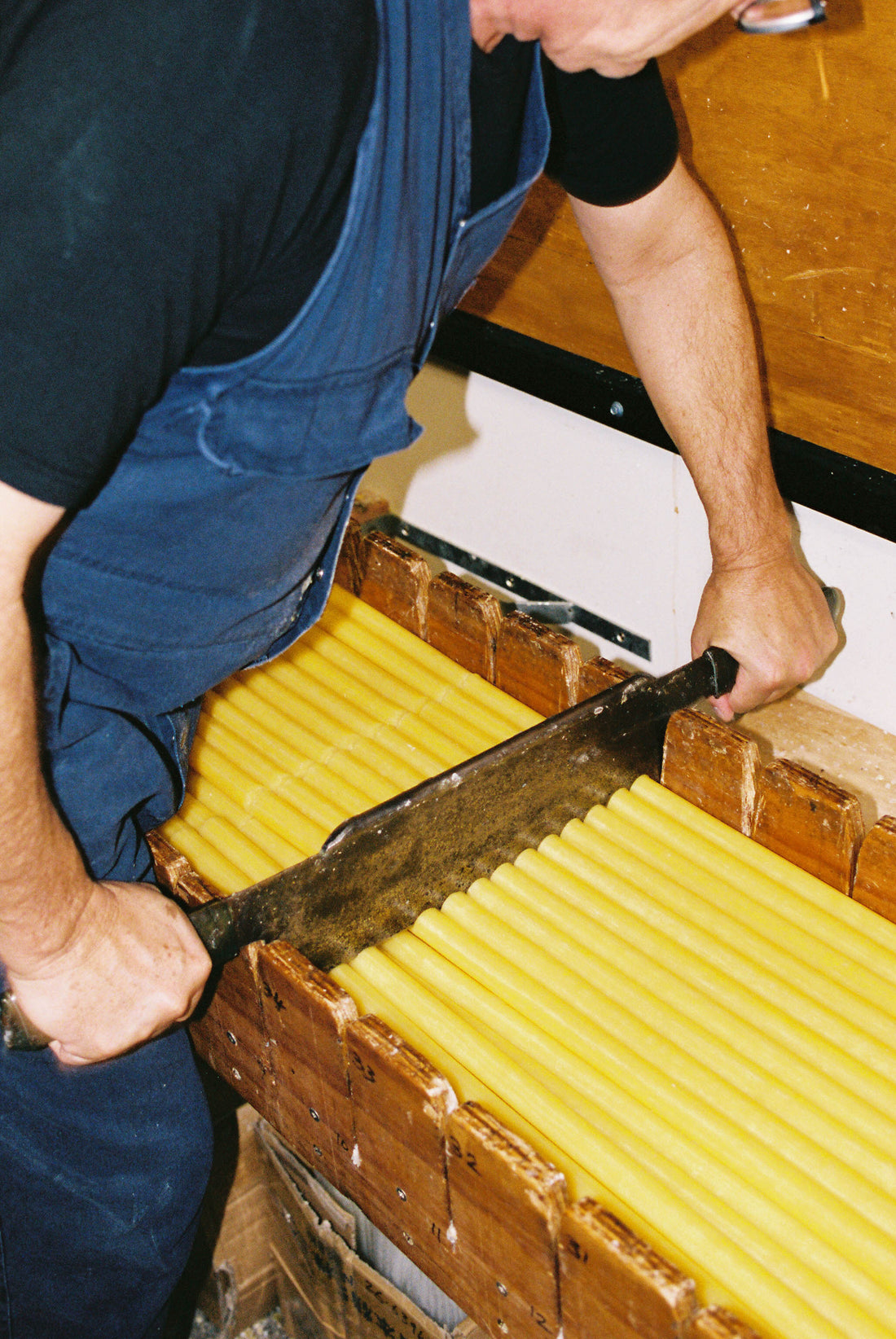 Person crafting beeswax candles at National Candles for Coffee Outdoors x National Candles Hut Candles.