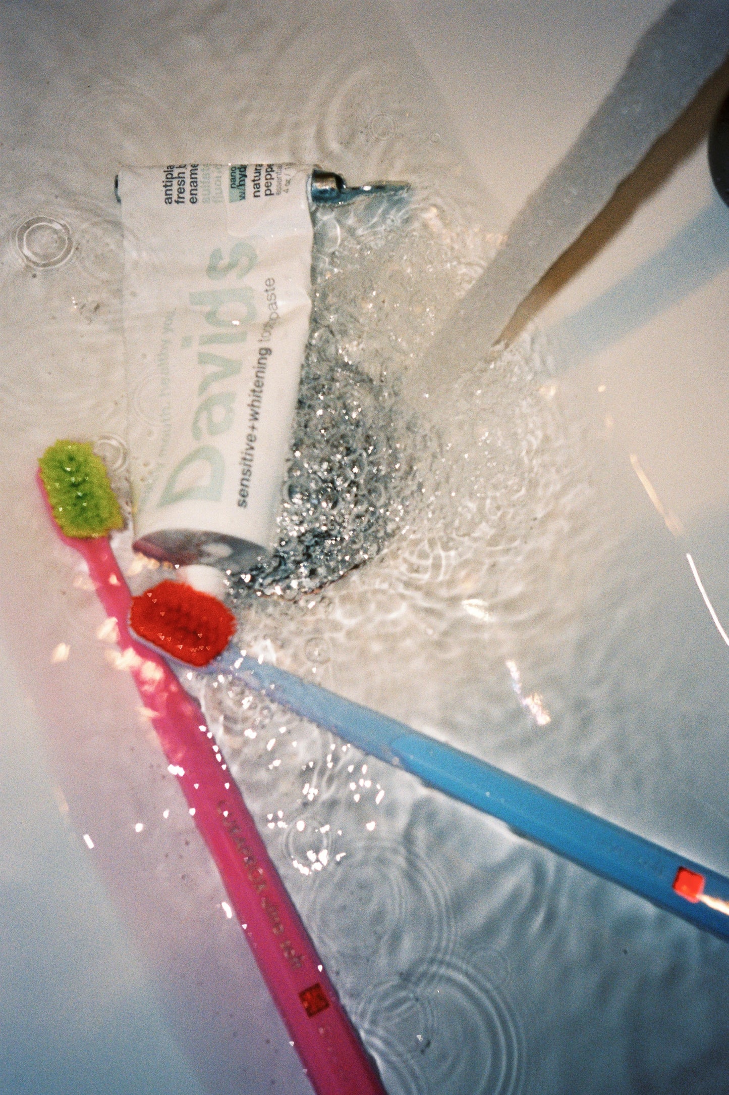 Davids Hydroxi™ Sensitive & Whitening Nano Hydroxyapatite Travel Toothpaste 50 grams - Peppermint with toothbrushes in water.