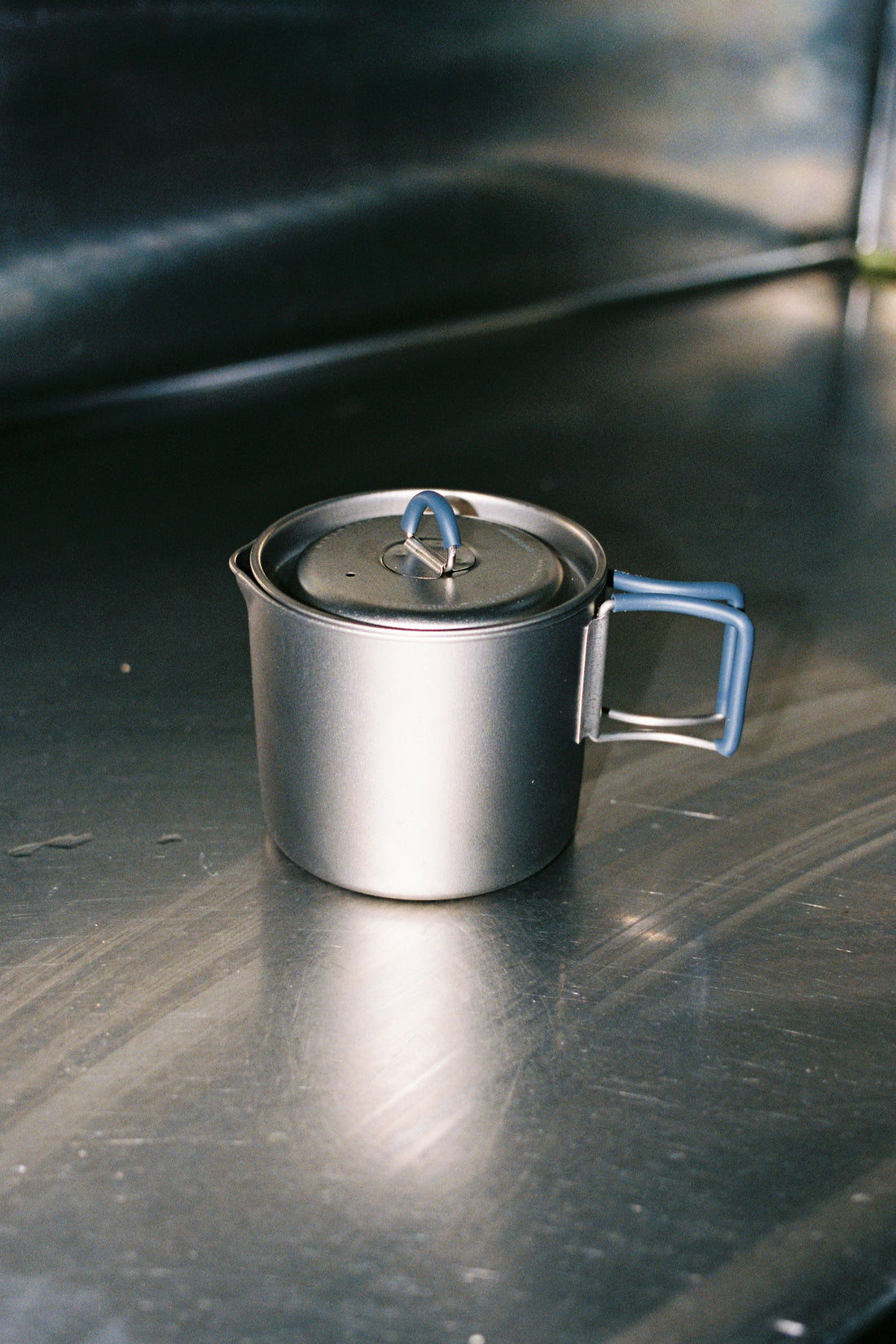 MP500 Flat Titanium Pot shown on a stainless steel surface, featuring a lid and handle for easy use.
