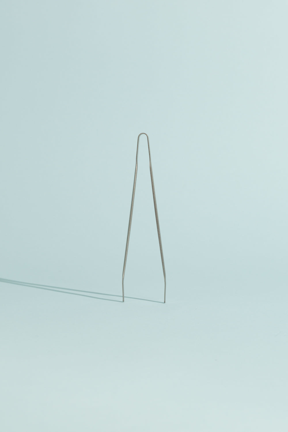 Evernew Meshitsucam Titanium Tongs on a light blue background, ideal for outdoor cooking and slurping noodles.