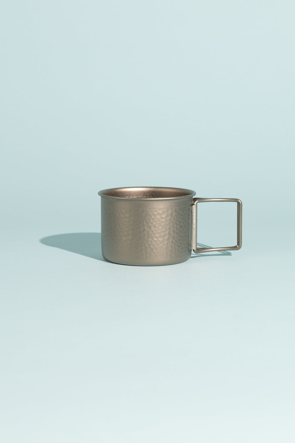 Evernew Dekoboco Titanium Cup with hammered finish against a pastel background, showcasing traditional craftsmanship.