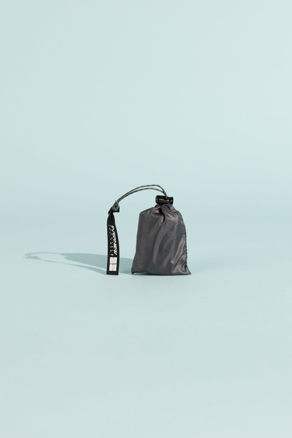 Compact gray storage bag with drawstring and handle for outdoor use.