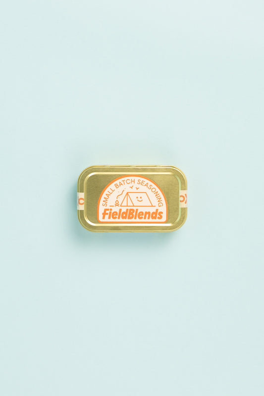 Field Blends Soy, Ginger & Sesame Camping Tin with small batch seasoning label on a light blue background.
