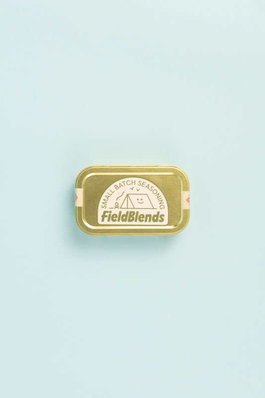 Field Blends Smokey Jalapeño & Peach - Camping Tin with small batch seasoning label on a light blue background.