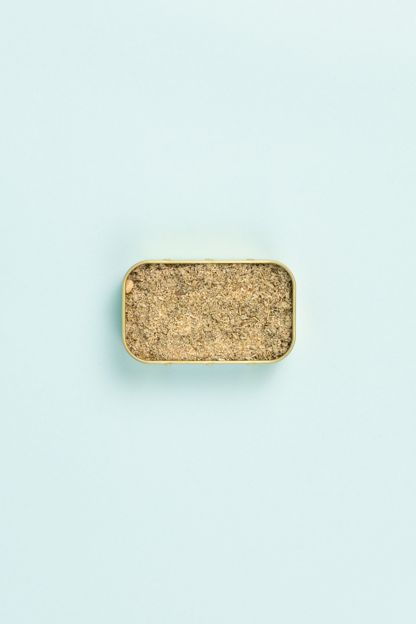 Field Blends Christmas Herb Blend in a camping tin on a light blue background.