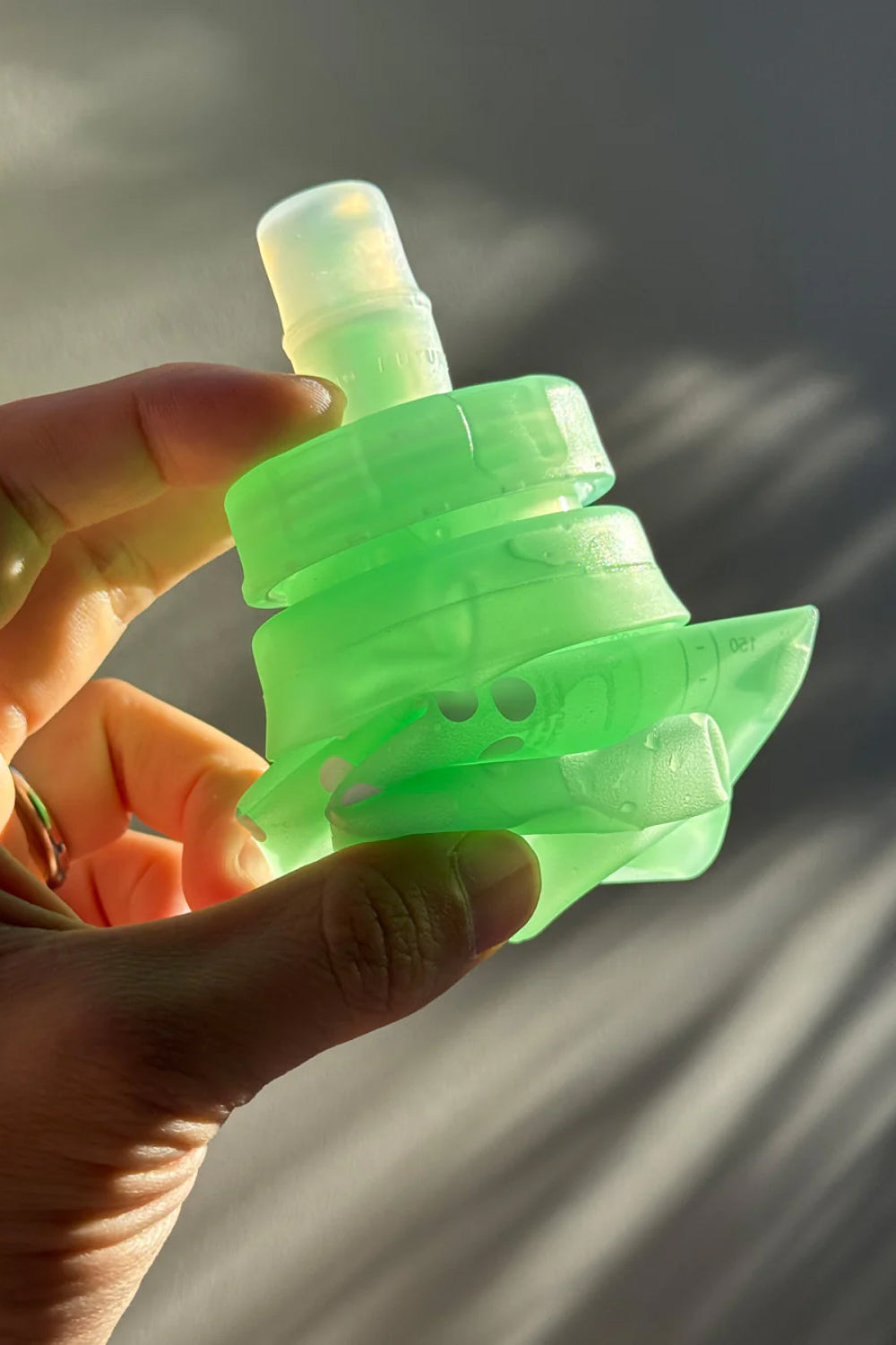 Person holding an OEM Soft Flask 473ml in green, showcasing its lightweight and collapsible design for hydration.