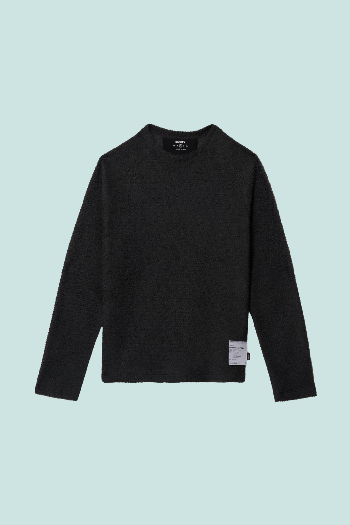 Satisfy FuzzFleece™ AD Long Tee - Phantom displayed on a light blue background, showcasing its soft texture.