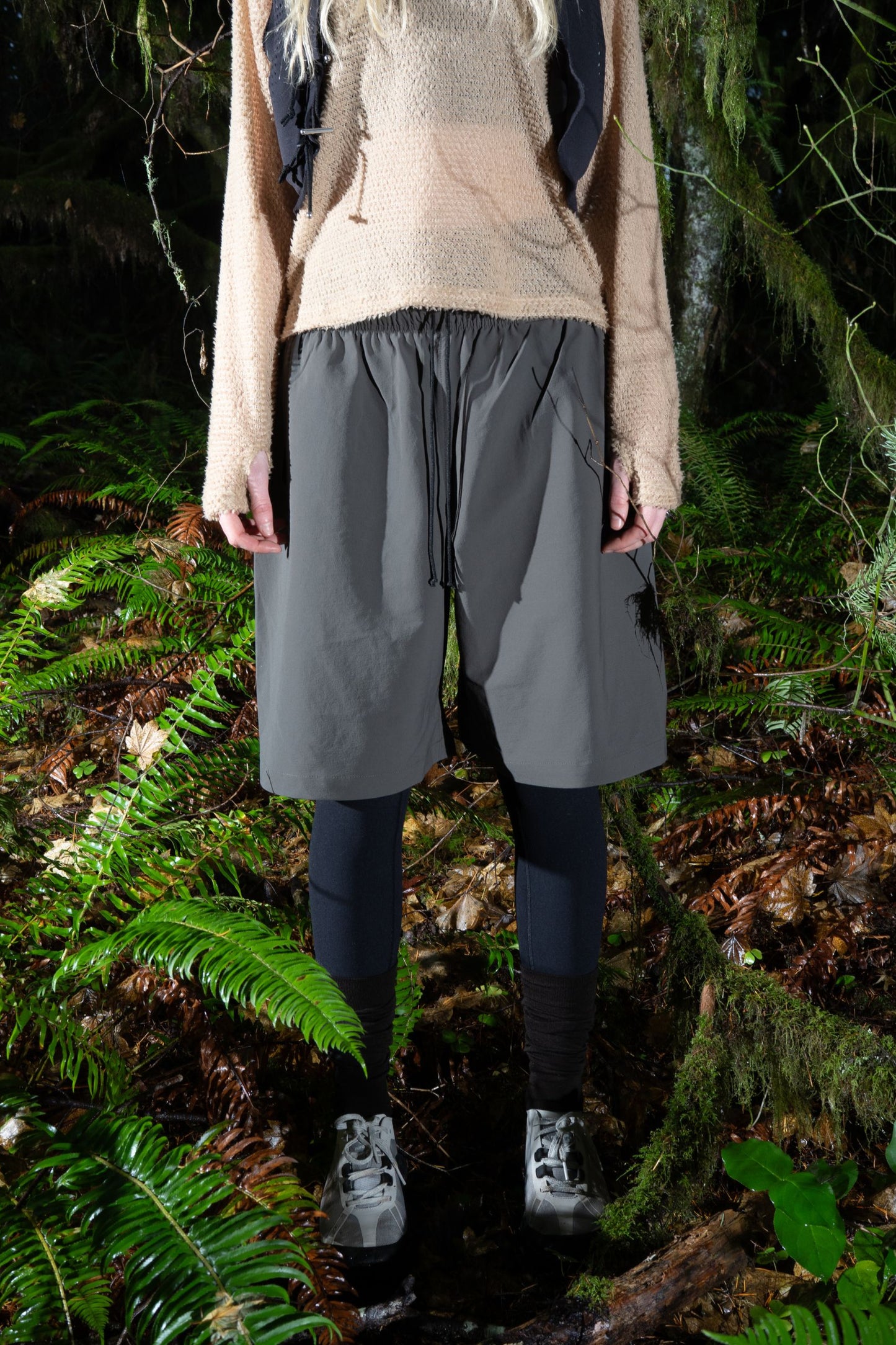 Model wearing Gnuhr Explora short in a natural forest setting showcasing its rugged design and comfort.