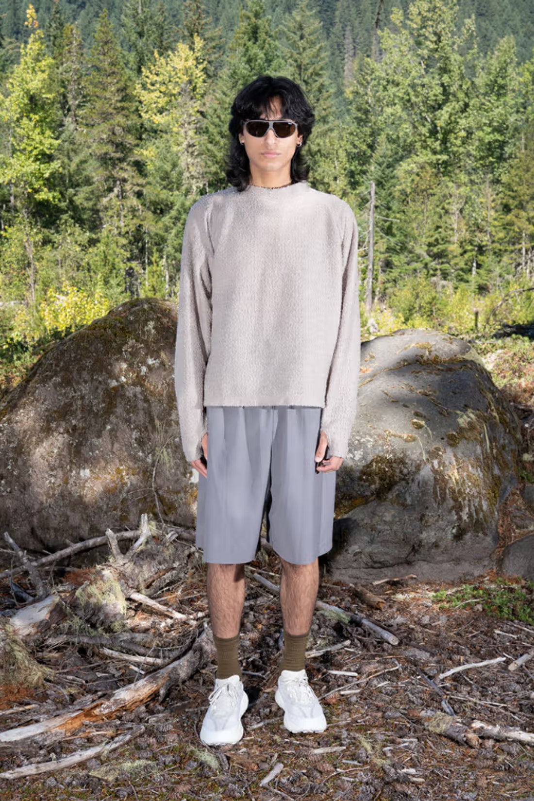 Gnuhr Warp Short Long - Charcoal worn by model in outdoor setting with trees and rocks.