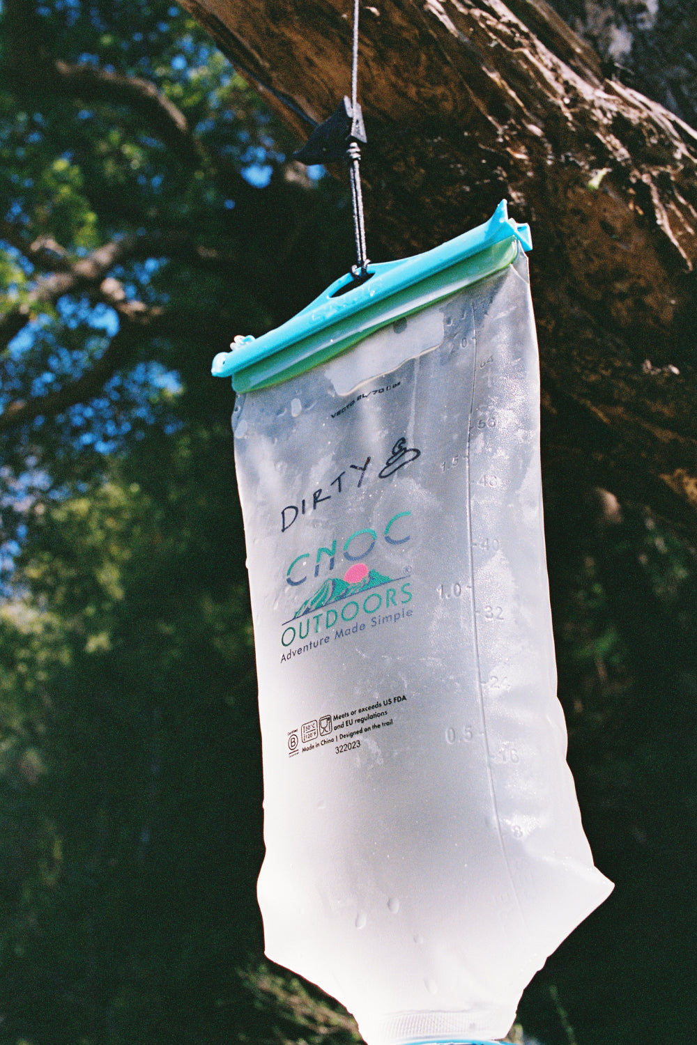 Gravity Water Filter System with CNOC Vecto water bladder hanging in a natural setting.