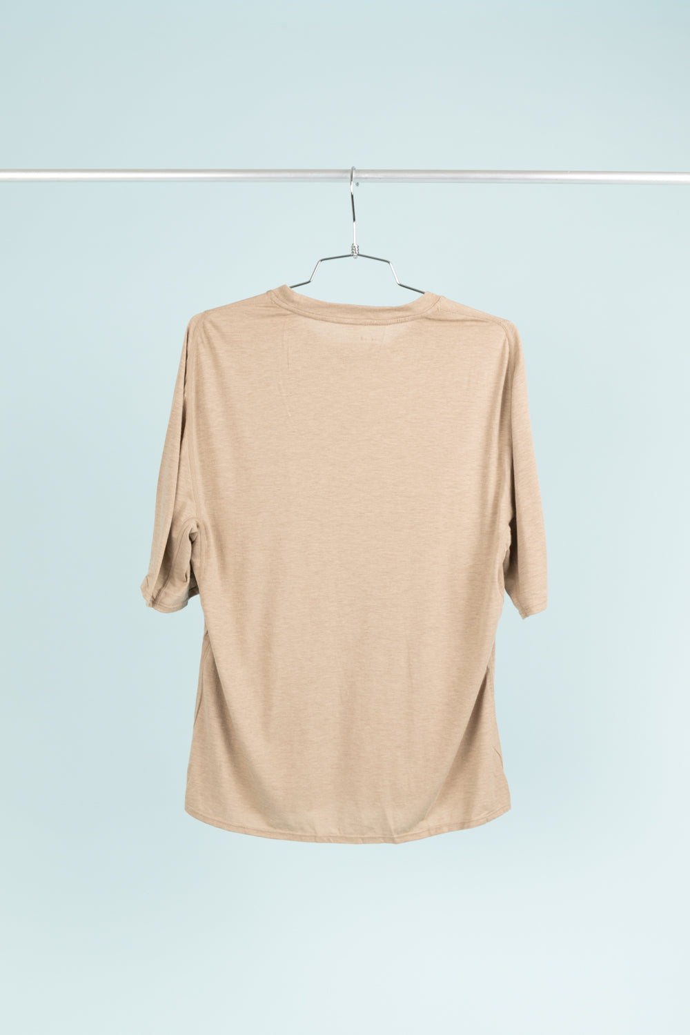 Back view of the Portal Drift Merino Tee in Desert Taupe, showcasing its ergonomic fit and soft fabric.