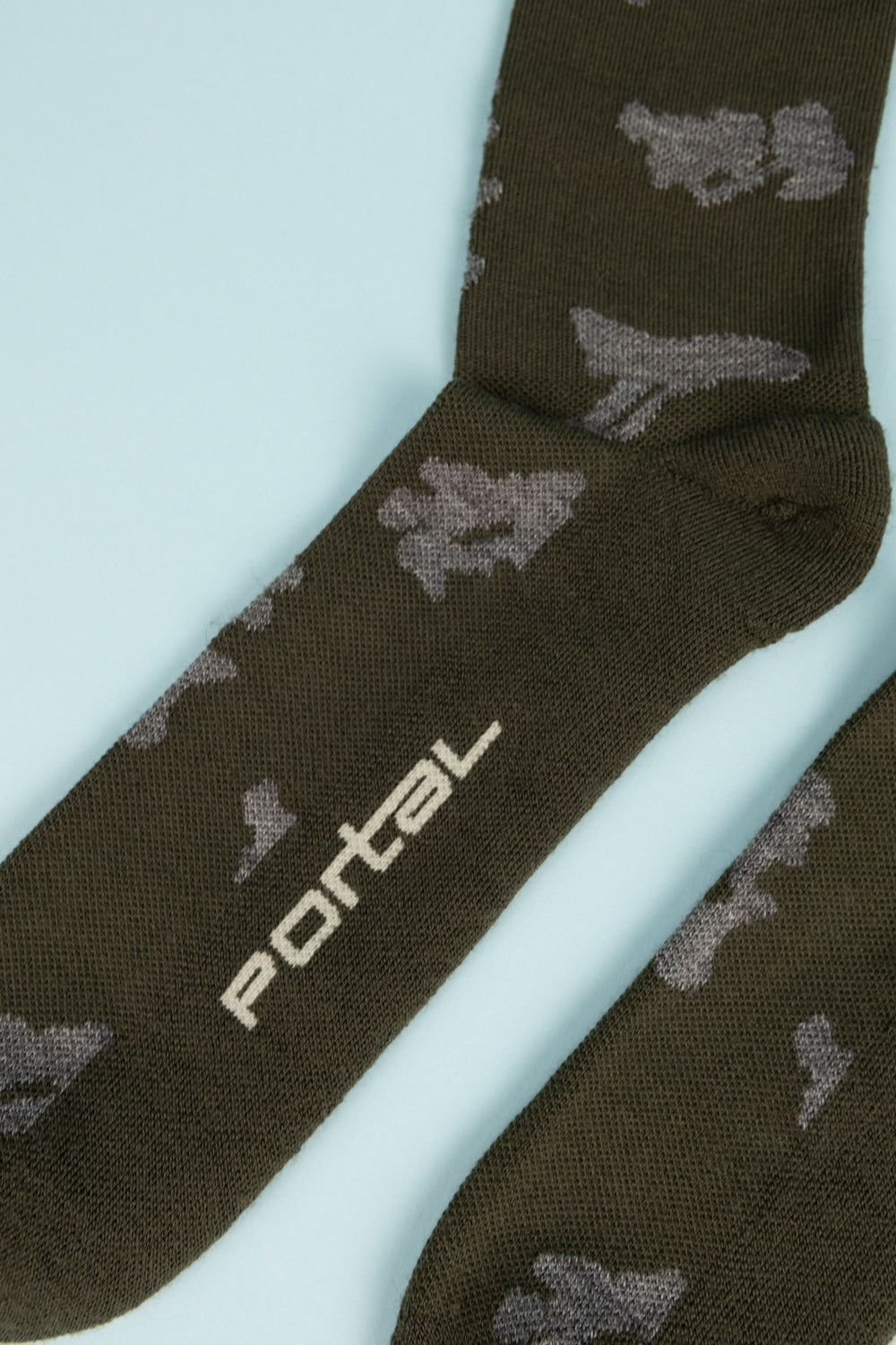 Close-up of Portal Ritual Merino Socks in Dark Olive featuring a stylish design and logo, ideal for active wear.