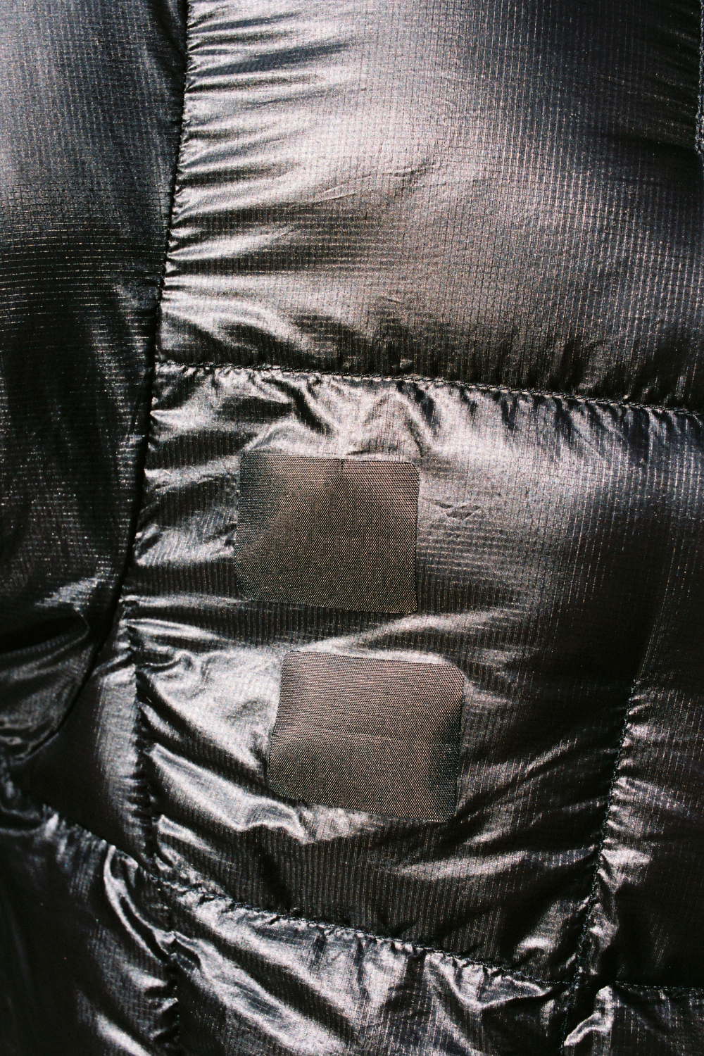 Igneous Gear Threadlock Patch applied on a black technical fabric jacket for repairs.
