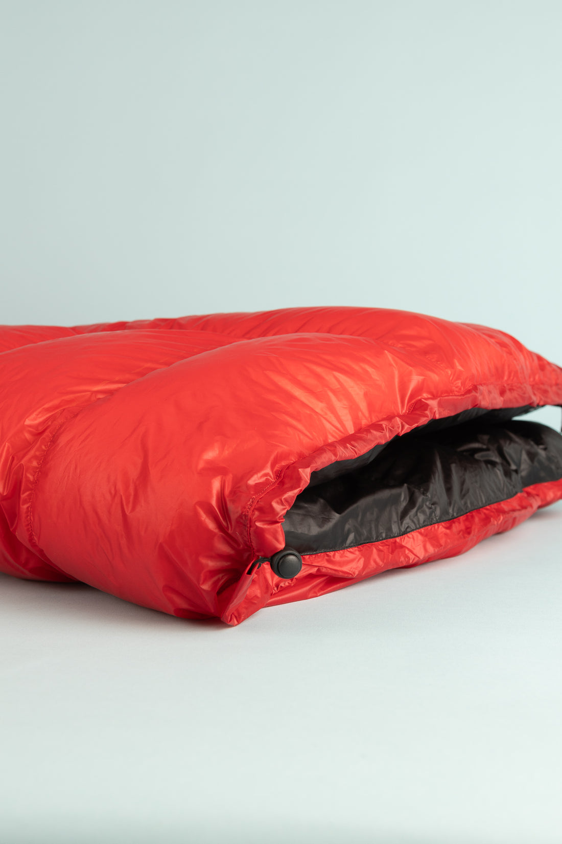 Kiwi Ultralight Quilt 850 Fill Down 0° - Red, showcasing the quilt's vibrant color and compact design for outdoor comfort.