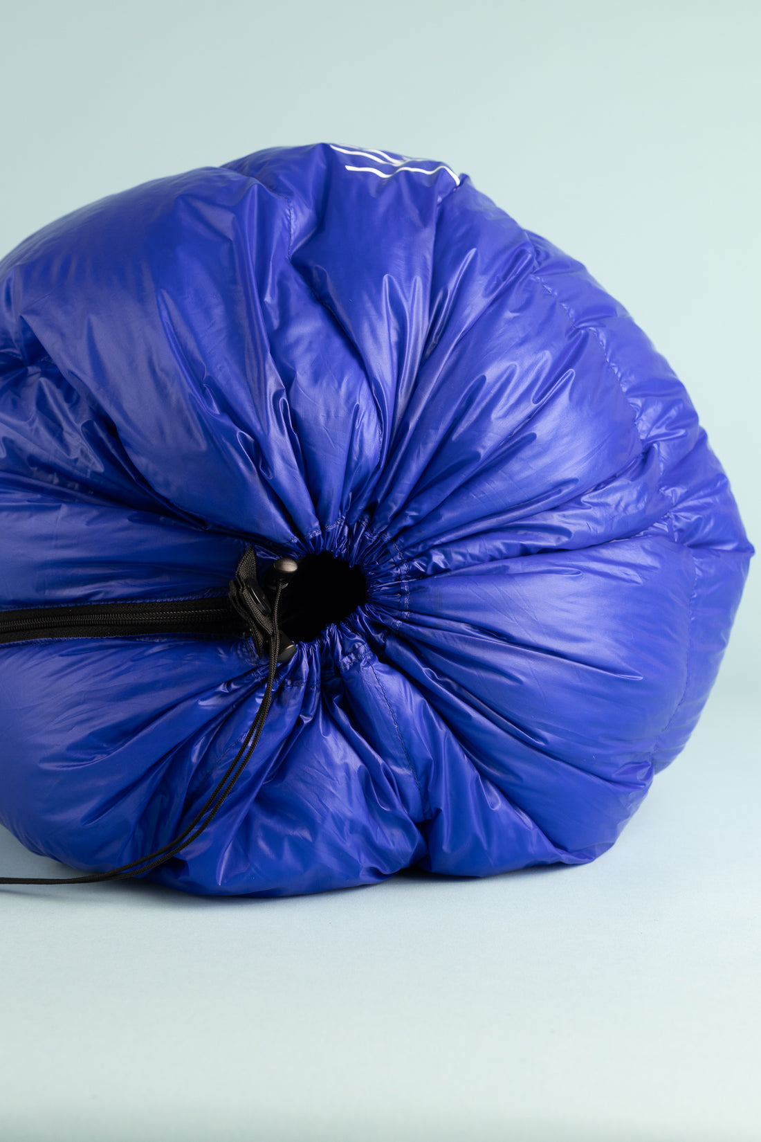Kiwi Ultralight Quilt 850 Fill Down -5° - Blue packed in a round shape for easy transport and storage.