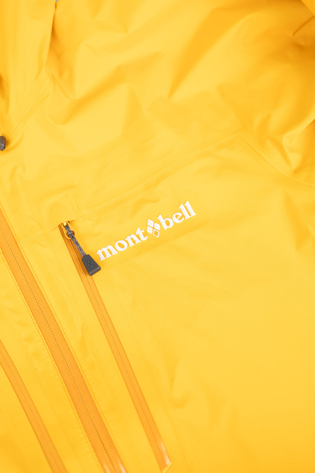 Montbell US Men's Tempest Jacket in bright orange with logo detail.