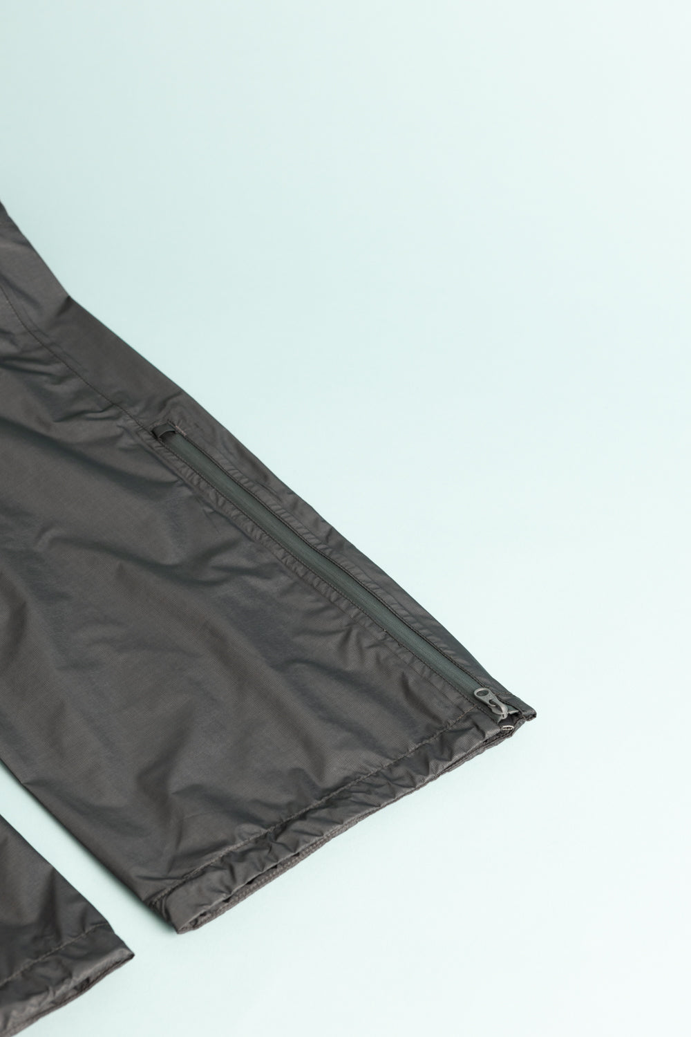 Montbell US Women's Dry-Tec U.L. Rain Pants in Dark Gray showing zippered pocket detail.