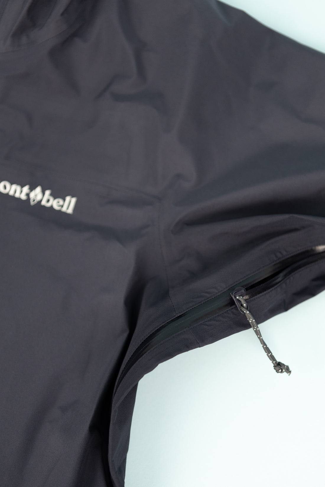 Montbell US Women's Tempest Jacket close-up view showing the navy fabric and logo detail.