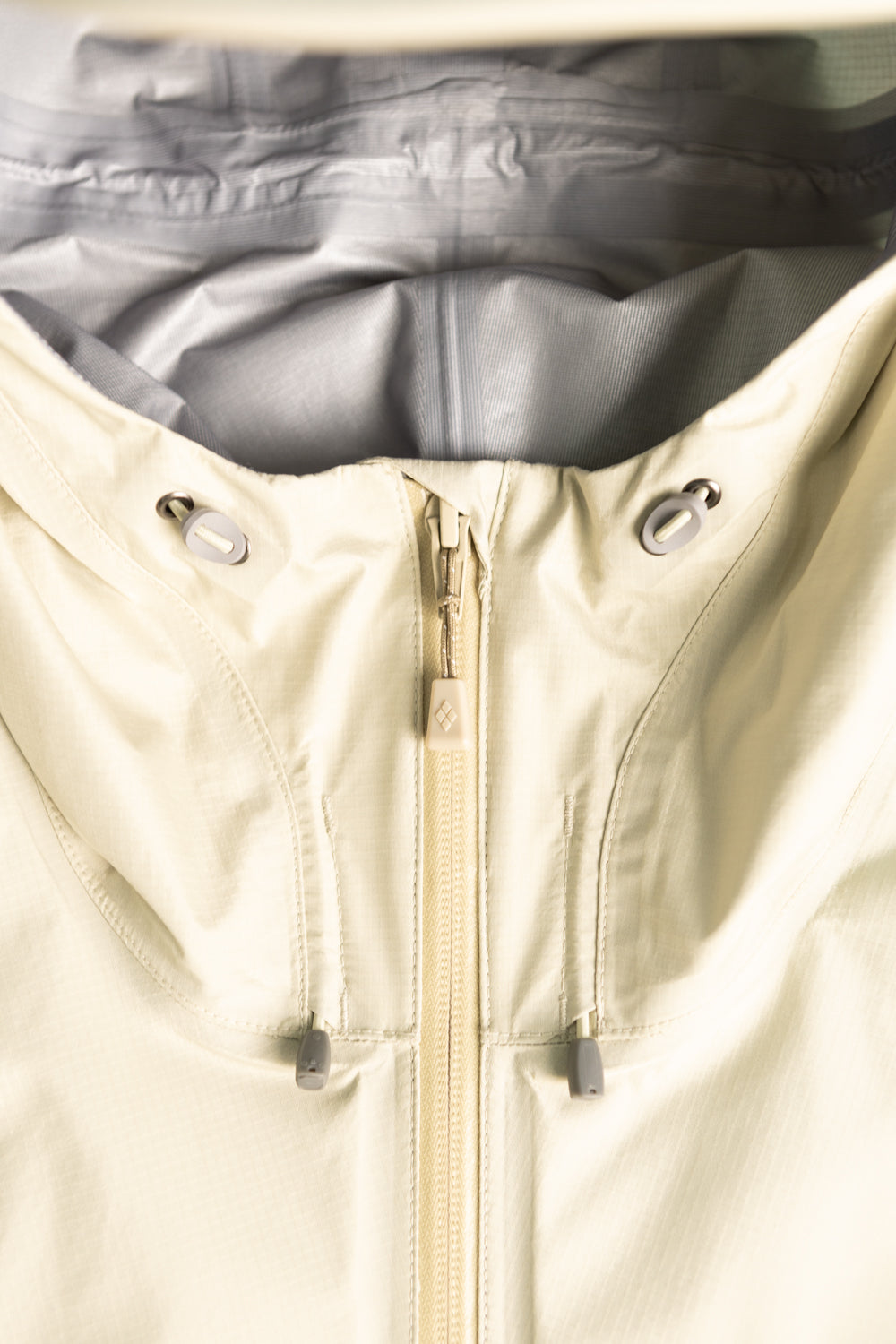 Montbell US Women's Rain Trekker Jacket - Ivory close-up view of zipped hood and interior lining.
