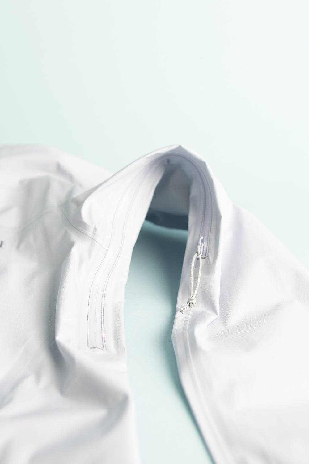 Montbell US Women's Tempest Jacket - Light Blue collar and zipper detail close-up on light background.