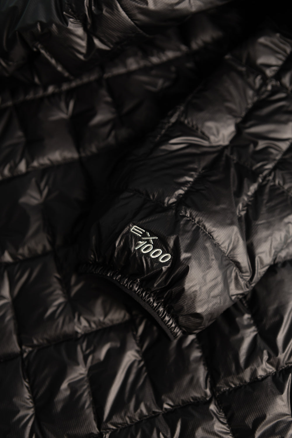 Montbell US Men's Plasma 1000 Down Jacket - Black close-up showing fabric and sleeve detail.