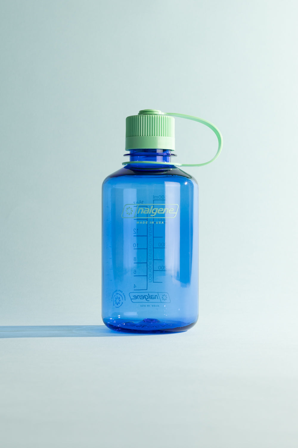 Nalgene Sustain N/M 500ml - Cornflower Blue bottle with green cap on a light background.