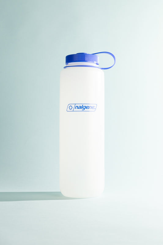 Nalgene Ultralite W/M 1.5L water bottle in natural color with blue cap on light background