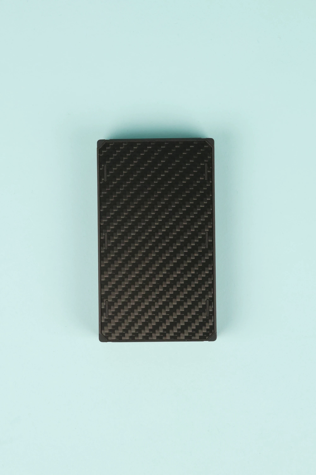 Nitecore NB20000 Powerbank Gen 3 top view showing a sleek carbon fiber design on a light blue background.