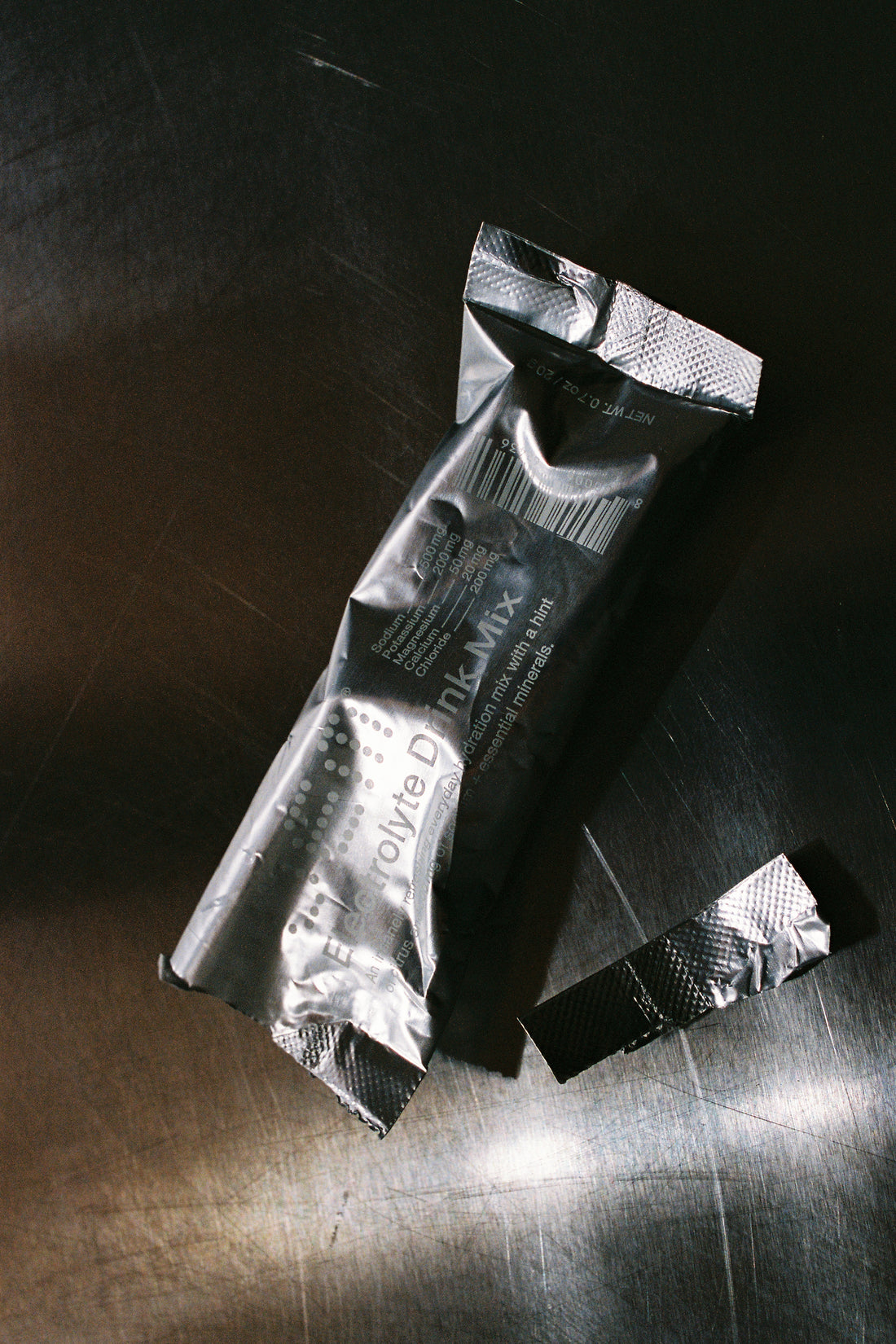 Electrolyte Drink Mix packet on a metal surface, showcasing hydration and muscle support.