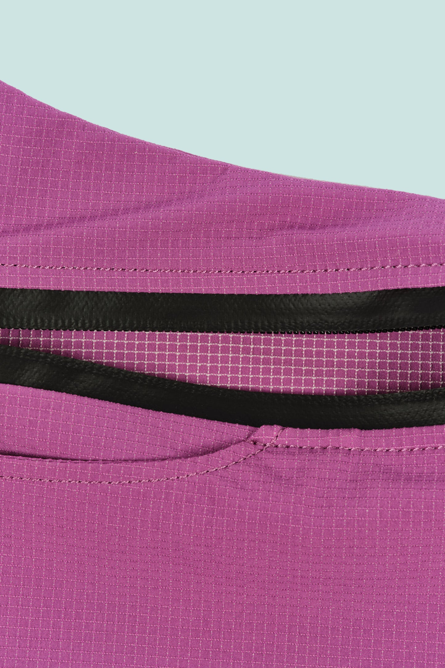 Close-up of the mauve fabric of Pa'lante x Bedrock sandals sidebag with zippered pocket and mesh detailing.