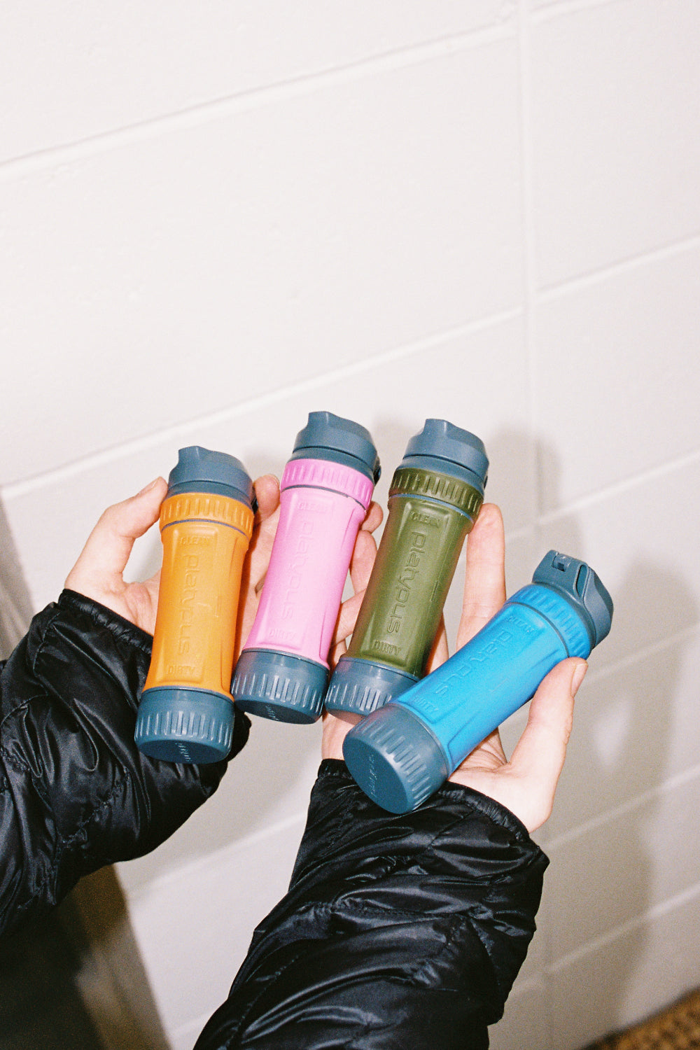 Platypus Quickdraw Filter Only + ConnectCap in four vibrant colors held in hands.
