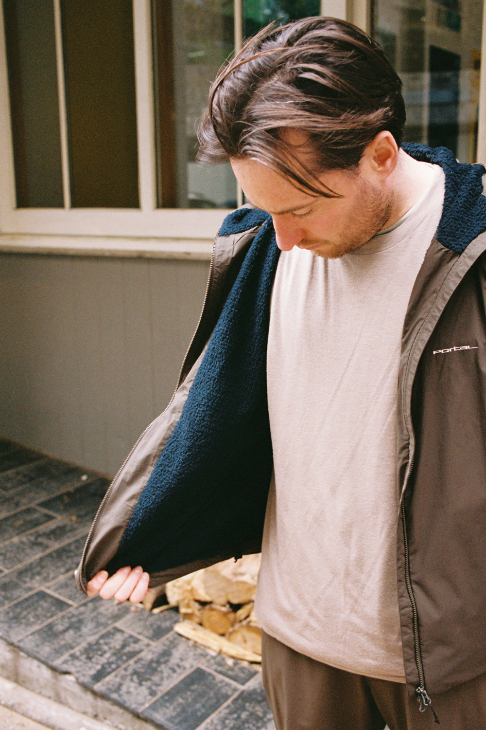 Man wearing Portal Level Alpha Jacket - Slate Black showcasing the insulated interior and outdoor setting.