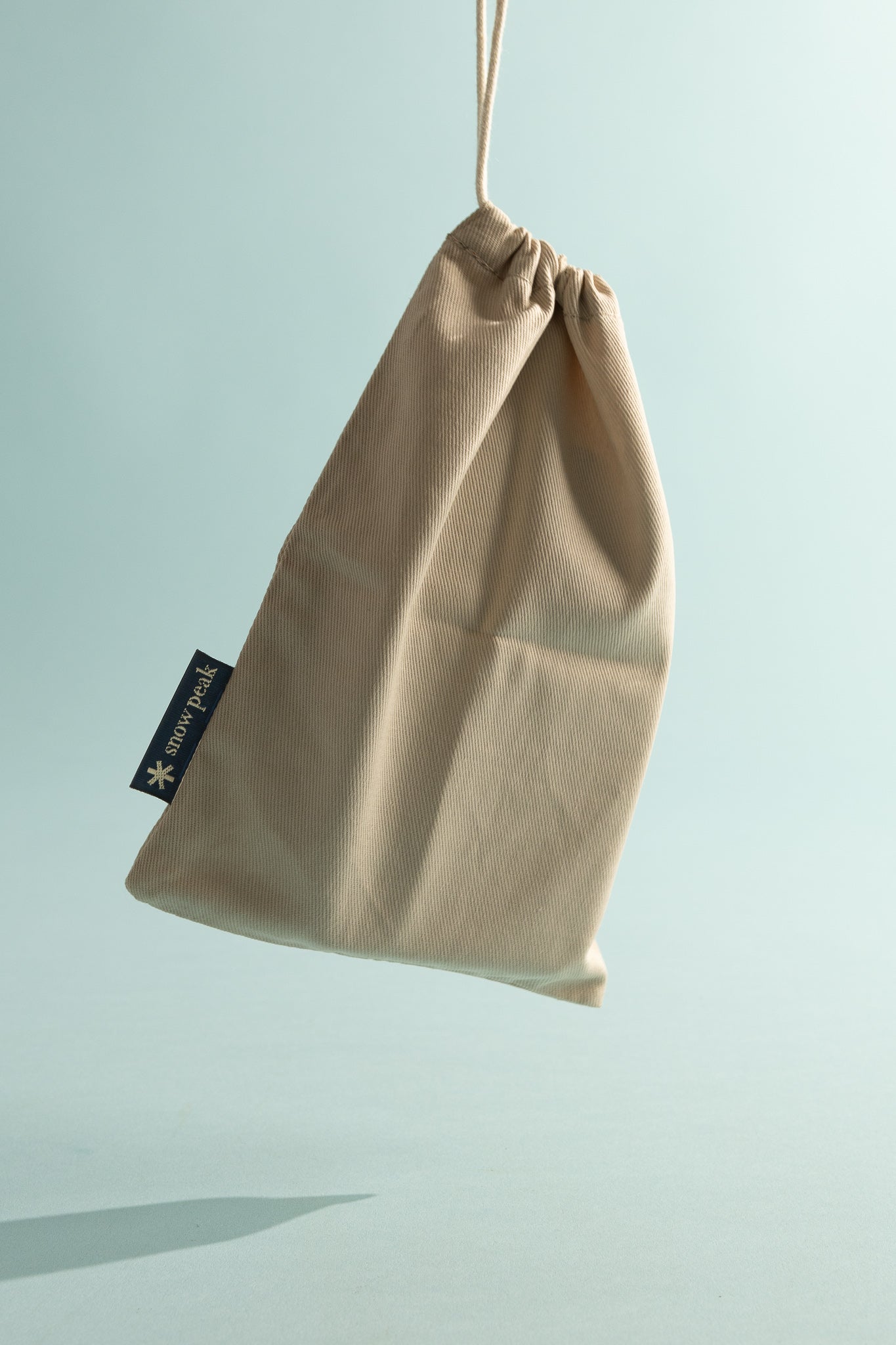 Snow Peak beige drawstring bag for carrying outdoor gear and accessories.