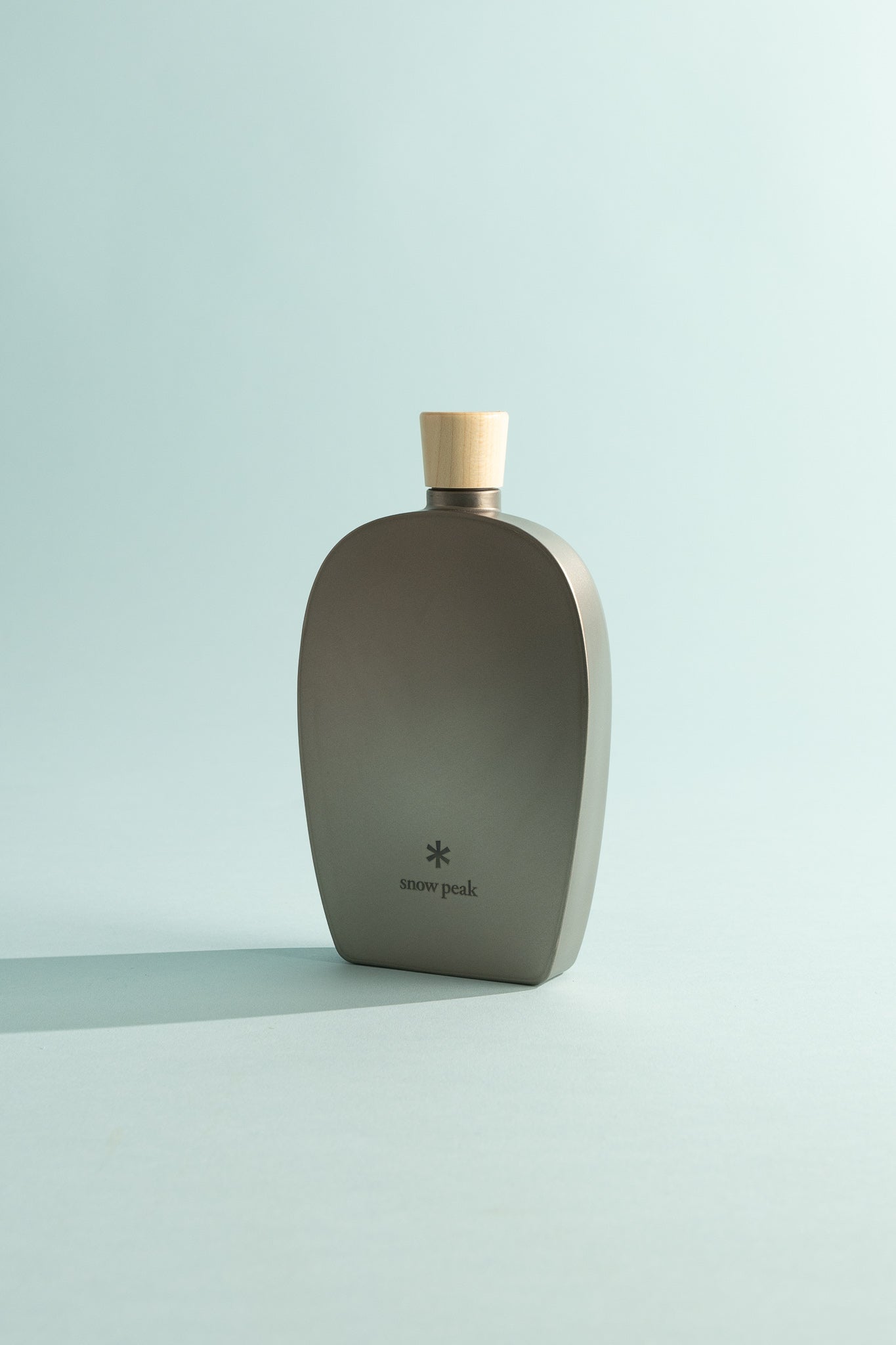 Snow Peak 250ml Titanium Flask with wooden cap on a light background