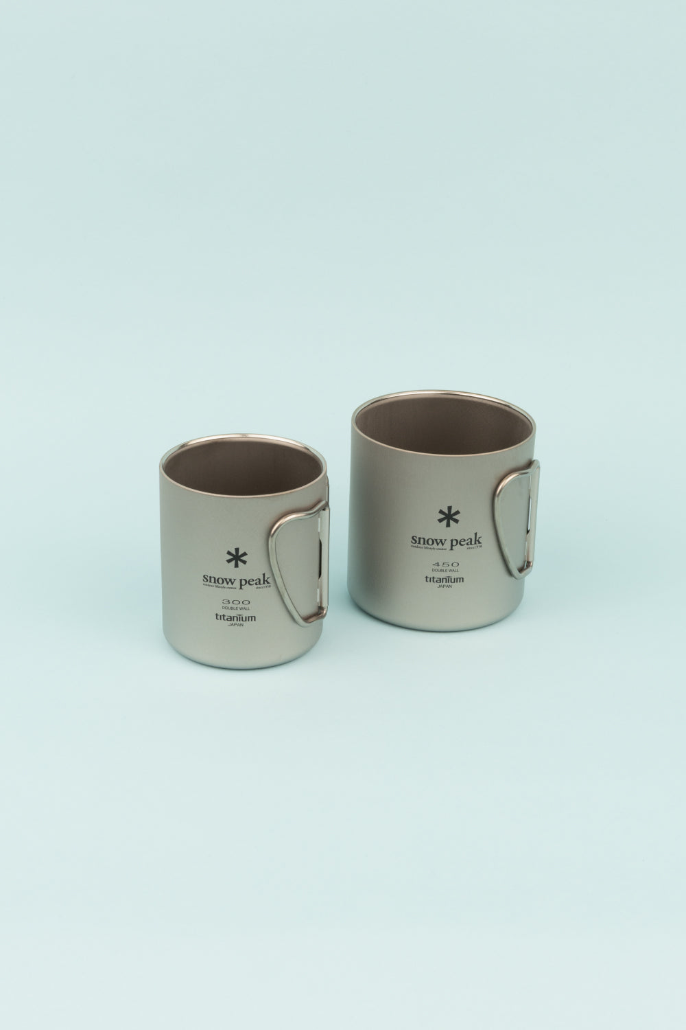 Snow Peak Double Wall Titanium Nesting Cup Set featuring two durable, ultralight camping mugs for hot beverages.
