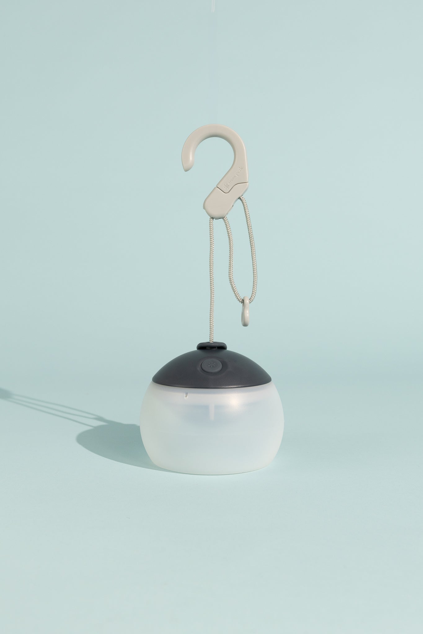 Snow Peak Rechargeable Hozuki Lantern - Night Sky hanging from a hook against a light blue background.