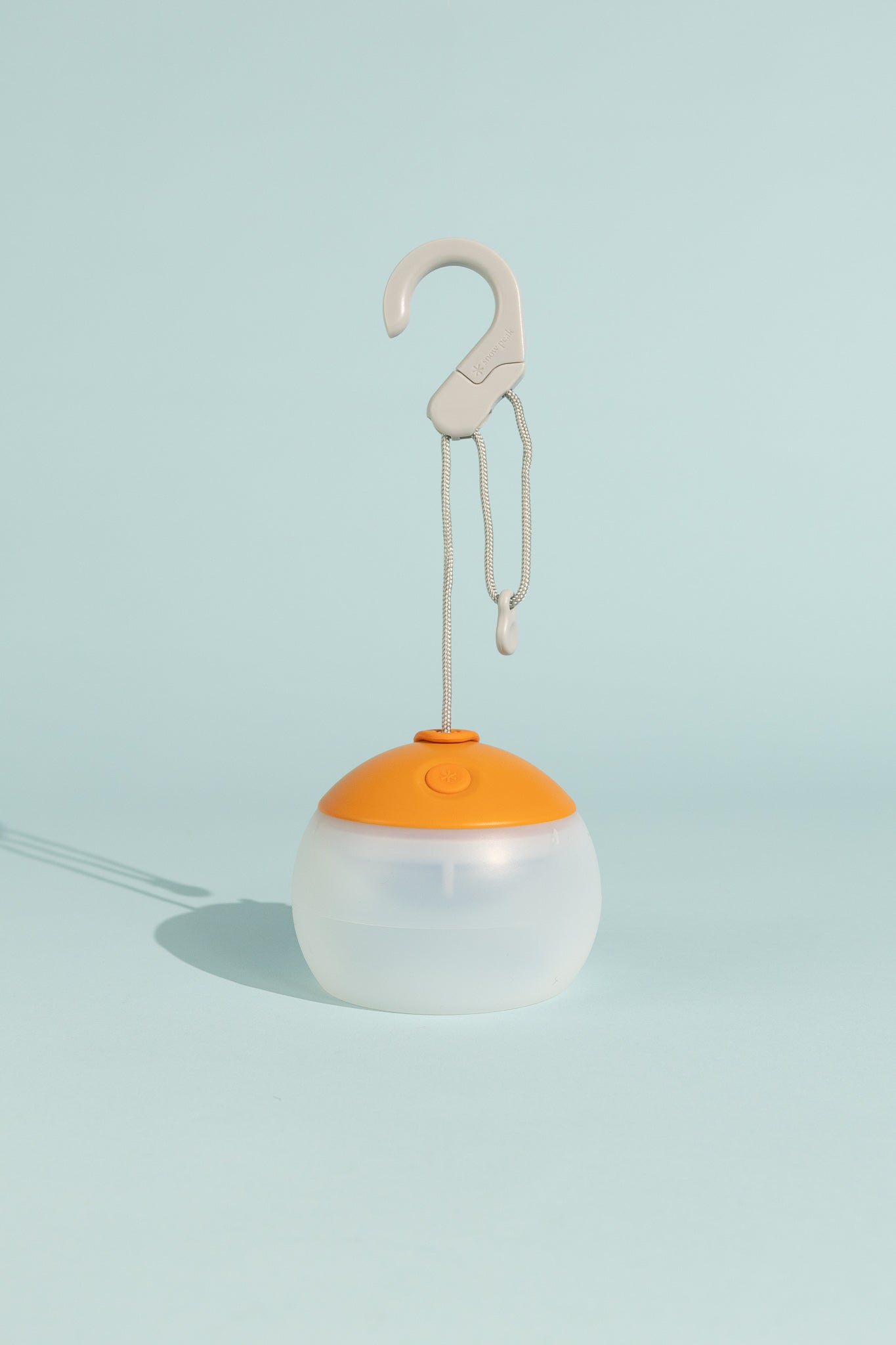 Snow Peak Rechargeable Hozuki Lantern - Twilight in a light blue background with a hook for hanging.