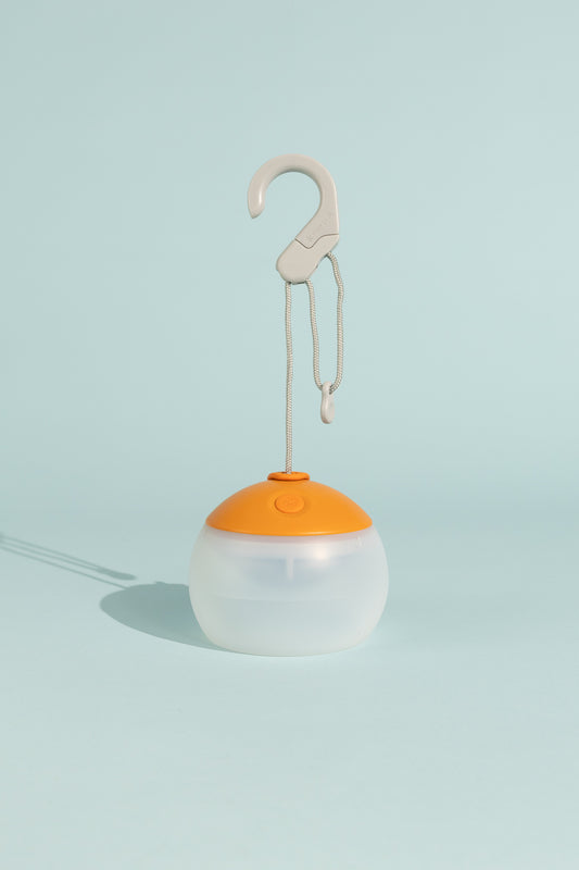 Snow Peak Rechargeable Hozuki Lantern - Twilight in a light blue background with a hook for hanging.